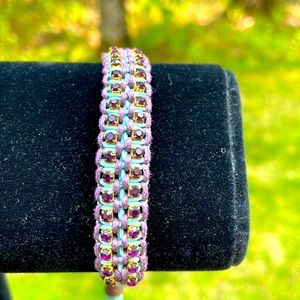 Woven bracelet with purple crystals.